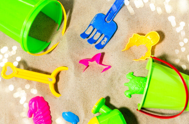 childhood and summer concept - close up of sand toys kit on beach