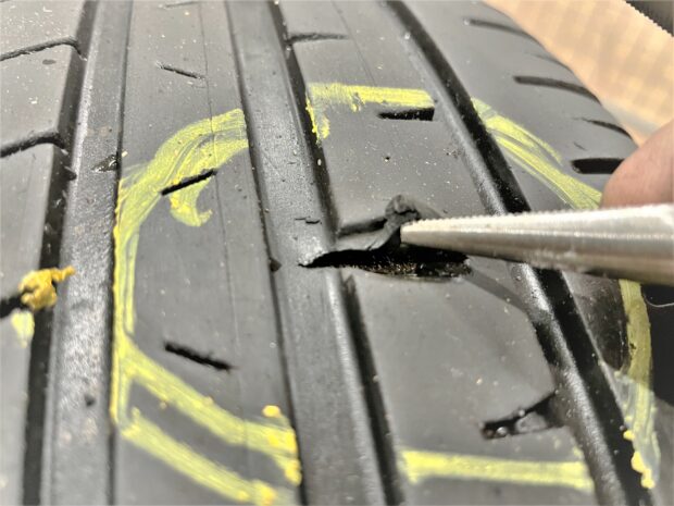 Cut in tread area on tyre opened up and shiny cords can be seen 