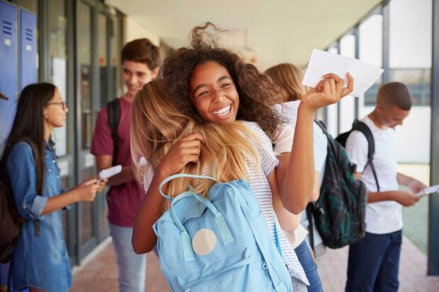 Students hugging each other after receiving exam results