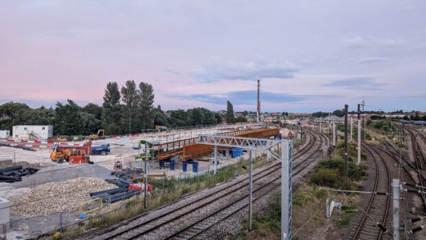 Industrial landscape showing a railway line with construction work taking place to the side of the tracks.