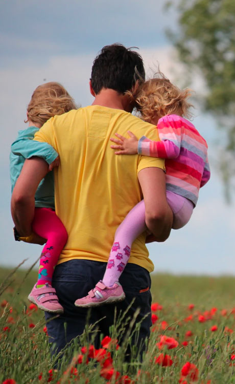man holding two children