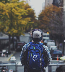 person stood in road with backpack on