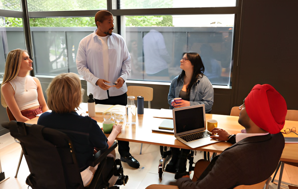 A diverse group of five professionals are engaged in a discussion.