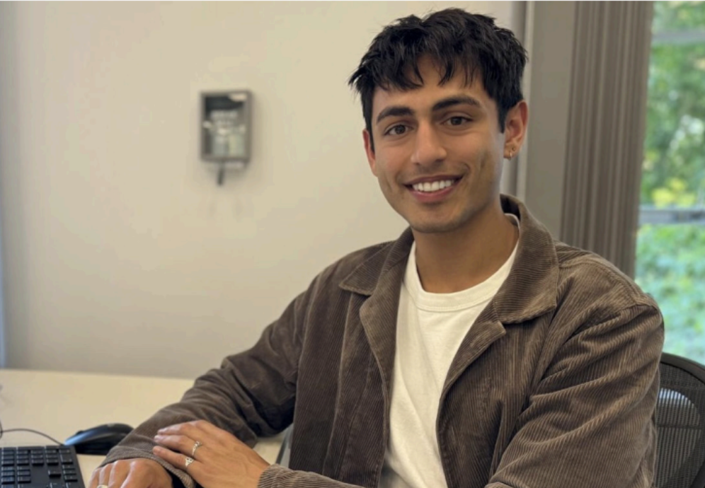 Chris Powell, a man sitting in front of a laptop computer. He is smiling.
