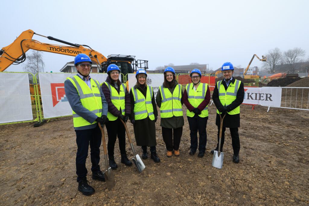 Six people, including UK Chancellor Rachel Reeves, standing in a line at a construction site for a groundbreaking ceremony.